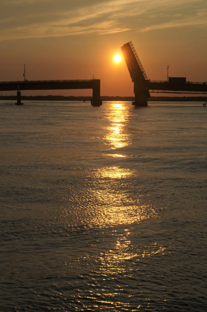 Townsend’s Inlet Bridge between Avalon and Sea Isle City, New Jersey at sunset with the drawbridge up for boats to pass below. Or a metaphor for sailing off into the sunset.